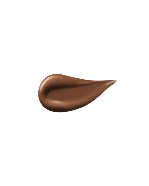 A smooth, glossy swipe of Radiant Fluid Foundation Natural is spread on a plain white background, highlighting the luxurious texture of this lightweight, long-lasting foundation.